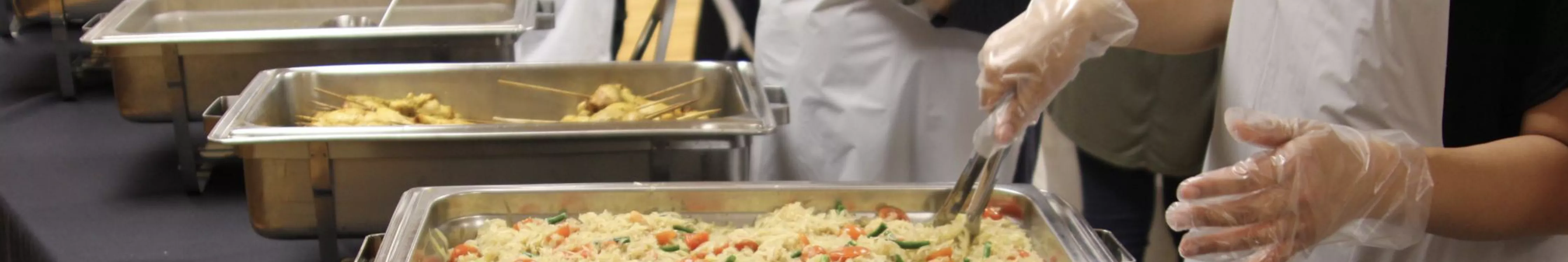 someone scooping food from a tray
