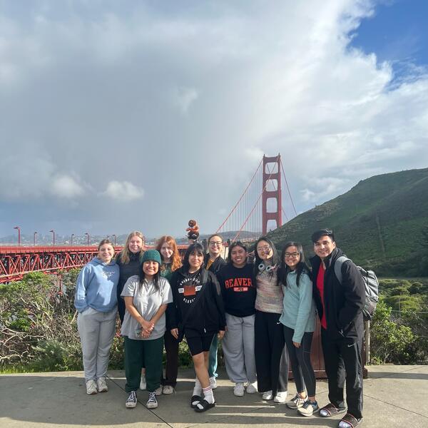 Group of people posing in front of a bridge